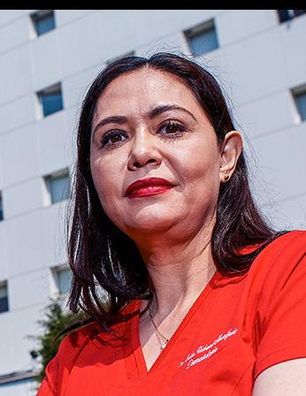 Es la foto de perfil de una dermatóloga en Ciudad de México de Hospital Angeles Lindavista. Tiene el cabello largo negro. Usa un uniforme médico y labial rojo.