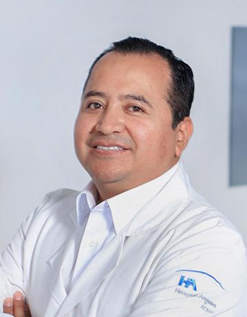 Es la foto de perfil de un radio-oncólogo y médico interno en Ciudad de México de Hospital Angeles. Tiene una bata blanca, los brazos cruzados y está sonriendo. 