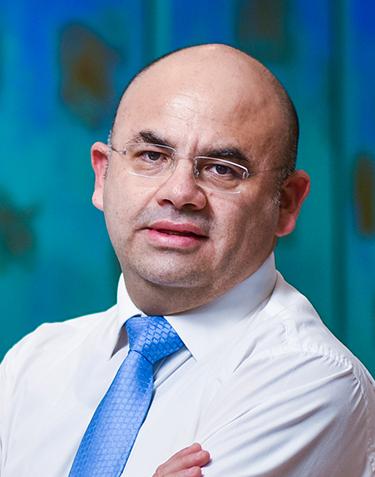 Es la foto de perfil de un pediatra en Villahermosa de Hospital Angeles Villahermosa. Usa una bata blanca y una corbata azul. Tiene los brazos cruzados.