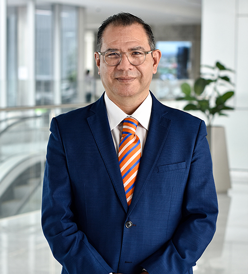 Es la foto de perfil de un gastroenterólogo en Querétaro de Hospital Angeles Centro Sur. Usa traje azul marino, corbata naranja con líneas azules y blancas.